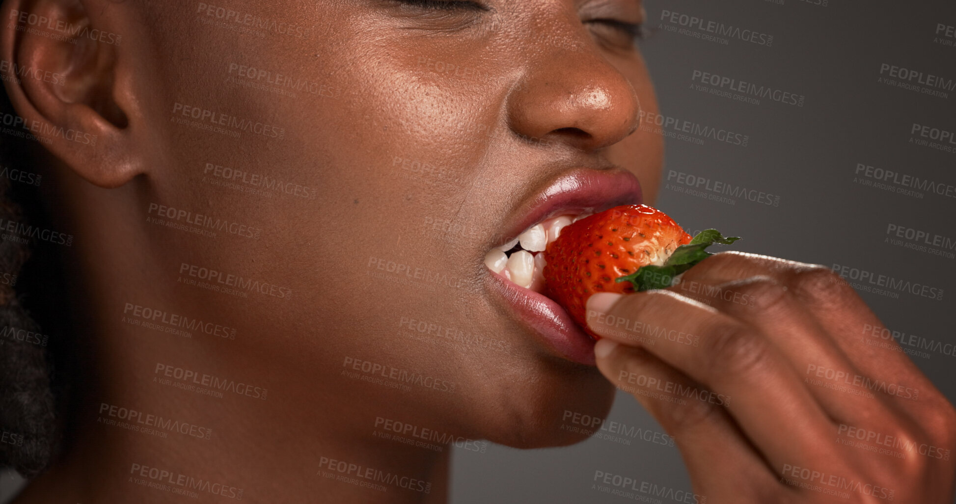 Buy stock photo Beauty, hand and strawberry with black woman in studio for organic benefits of healthy eating. Fruit, nutrition and vitamins with African model on gray background for diet, detox or weight loss