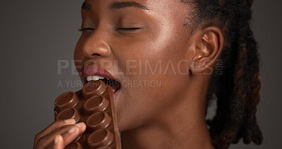 Buy stock photo Diet, eat or black woman in studio with chocolate bar, poor nutrition or calories in sugar treat. Food, unhealthy or female person on gray background with bite, candy or carbohydrate in cacoa snack.