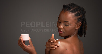 Buy stock photo Black woman, skincare and cream for shoulder in studio, tub and mock up space on dark background. African girl, beauty and container with lotion, cosmetics and application for dermatology product