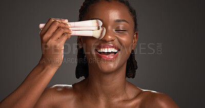 Buy stock photo Brushes, makeup and happy black woman in studio for cosmetics, makeover and application. Cosmetology, space and person with tools for foundation, beauty products and aesthetic on dark background