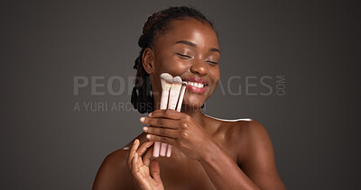 Buy stock photo Brush, makeup and black woman in studio for cosmetics, makeover and application. Cosmetology, mockup space and person with tools for foundation, beauty products and salon aesthetic on dark background