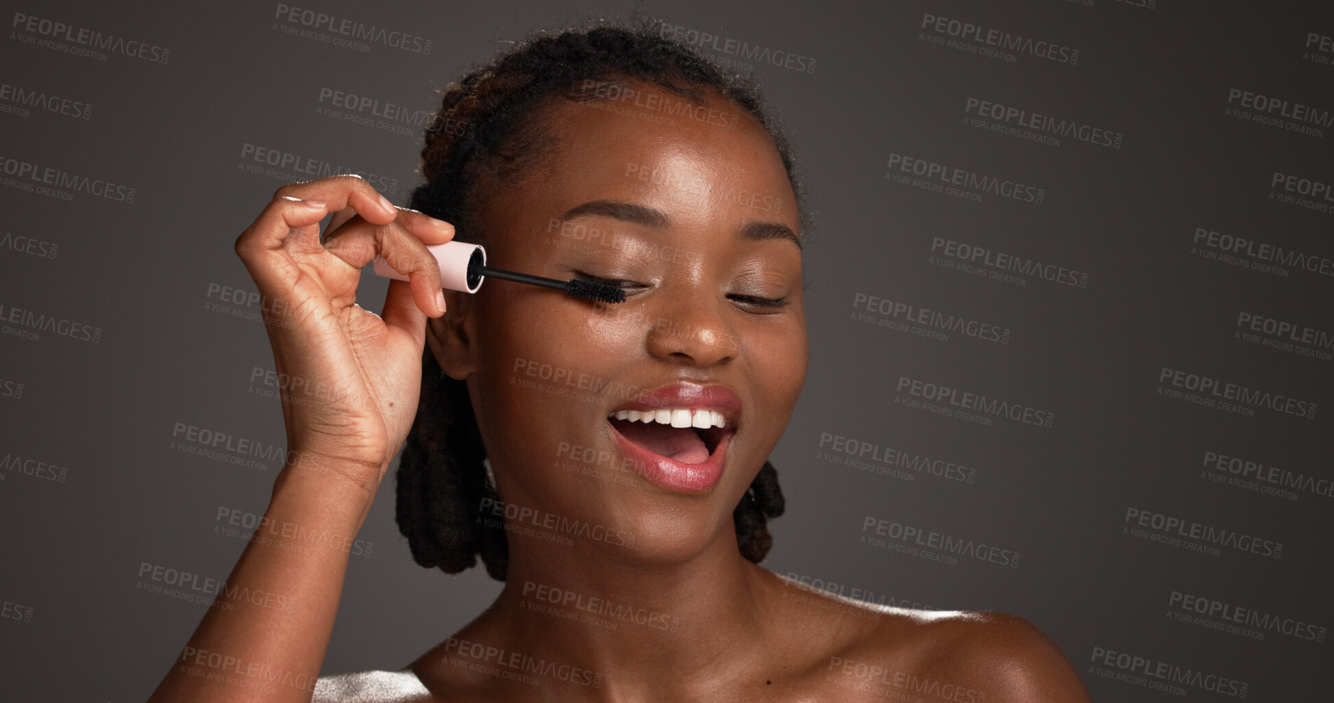 Buy stock photo Mascara, application and black woman in studio for cosmetics, volume and length boost in eye prep. Beauty, smile and female person on gray background with tool, natural or lash lift with makeup