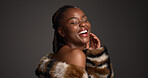 Luxury skincare, beauty and black woman laugh in studio with glow, self care and glamour. Makeup, cosmetics and model with fur coat for aesthetic, healthy skin and funny on dark background space