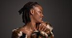 Proud, black woman and makeup for beauty in studio with cosmetics, facial glow and aesthetic. Space, female person and wellness with luxury shine, fur coat and glamour for makeover on gray background