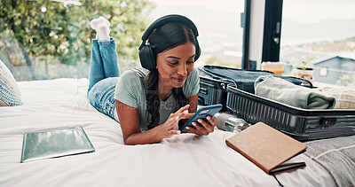 Buy stock photo Music, phone and typing with woman in hotel for travel blog, streaming service and luggage. Radio subscription, trip research and resort review with person and headphones in house rental for contact