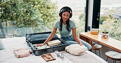 Buy stock photo Packing, bedroom and woman with suitcase, headphones and clothes for vacation, audio and smile. Home, travel and happy person with holiday trip, luggage and listening to music, tourism and prepare