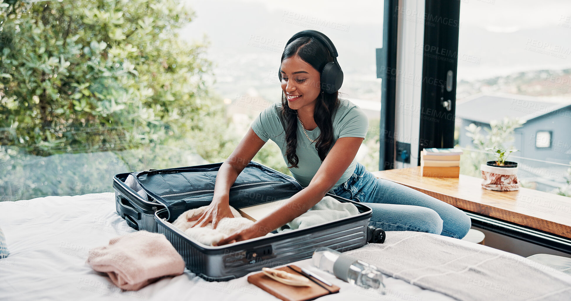 Buy stock photo Packing, house and woman with luggage, headphones and clothes for vacation, sound and smile. Suitcase, travel and happy person with audio, holiday trip and listening to music, tourism and baggage