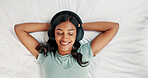 Relax, happy woman and listening with headphones on bed, digital subscription service and podcast from above. Weekend rest, radio and person streaming music with tech, chilling and audiobook in home
