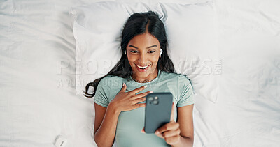 Buy stock photo Earphones, surprise and woman with phone on bed, reading and listening for mystery audiobook from above. Suspense, audio story and person with shock for chapter drama, tech and plot twist in home