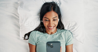 Buy stock photo Earphones, happy woman and listening with phone on bed, reading digital book or website from above. Audio tech, online story and person with mobile app for ebook, streaming music or podcast in home