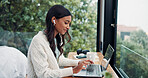 Earphones, laptop and remote work with woman at window in home for online planning or research. Computer, typing and view with freelance employee at desk in apartment for small business startup