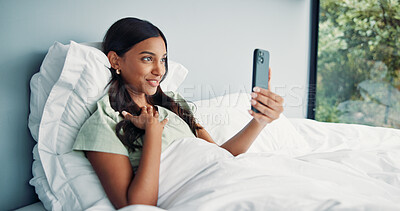 Buy stock photo Relax, happy woman or video call with phone on bed, online communication or morning chat on weekend. Digital app, comfortable and Indian person talking with mobile, connection or conversation in home