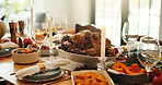Table, setup and turkey for thanksgiving at house for social gathering, vegetables and celebration. Candles, feast and cuisine layout with wine glass, nutrition meal and lunch tradition for festive