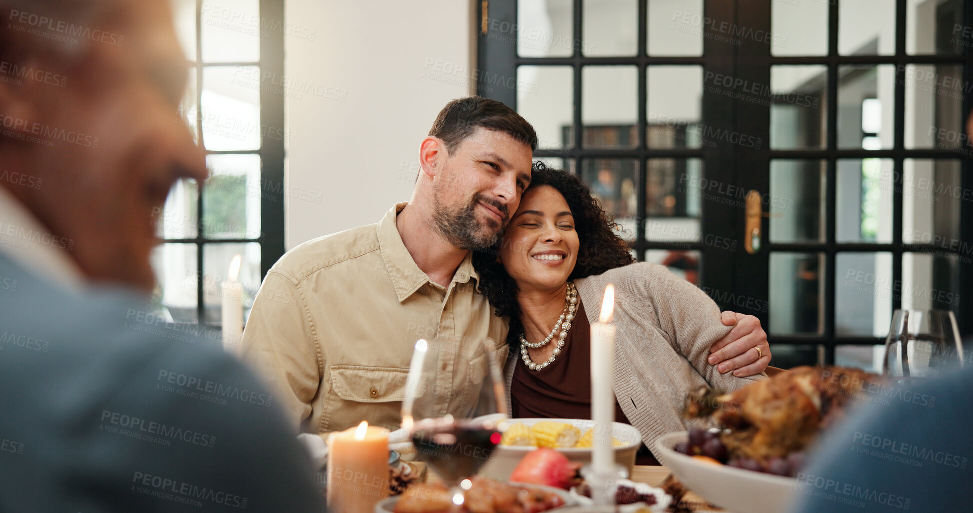 Buy stock photo Celebration, Christmas and hug with couple in dining room of home together for family gathering. Food, holiday tradition and love with happy people at table for banquet, dinner or festive feast