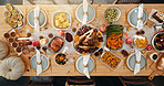 Above, table and food for thanksgiving at house with roast turkey, health vegetables and celebration. Candles, feast and cuisine setup with wine glass, nutrition meal and lunch tradition for festive