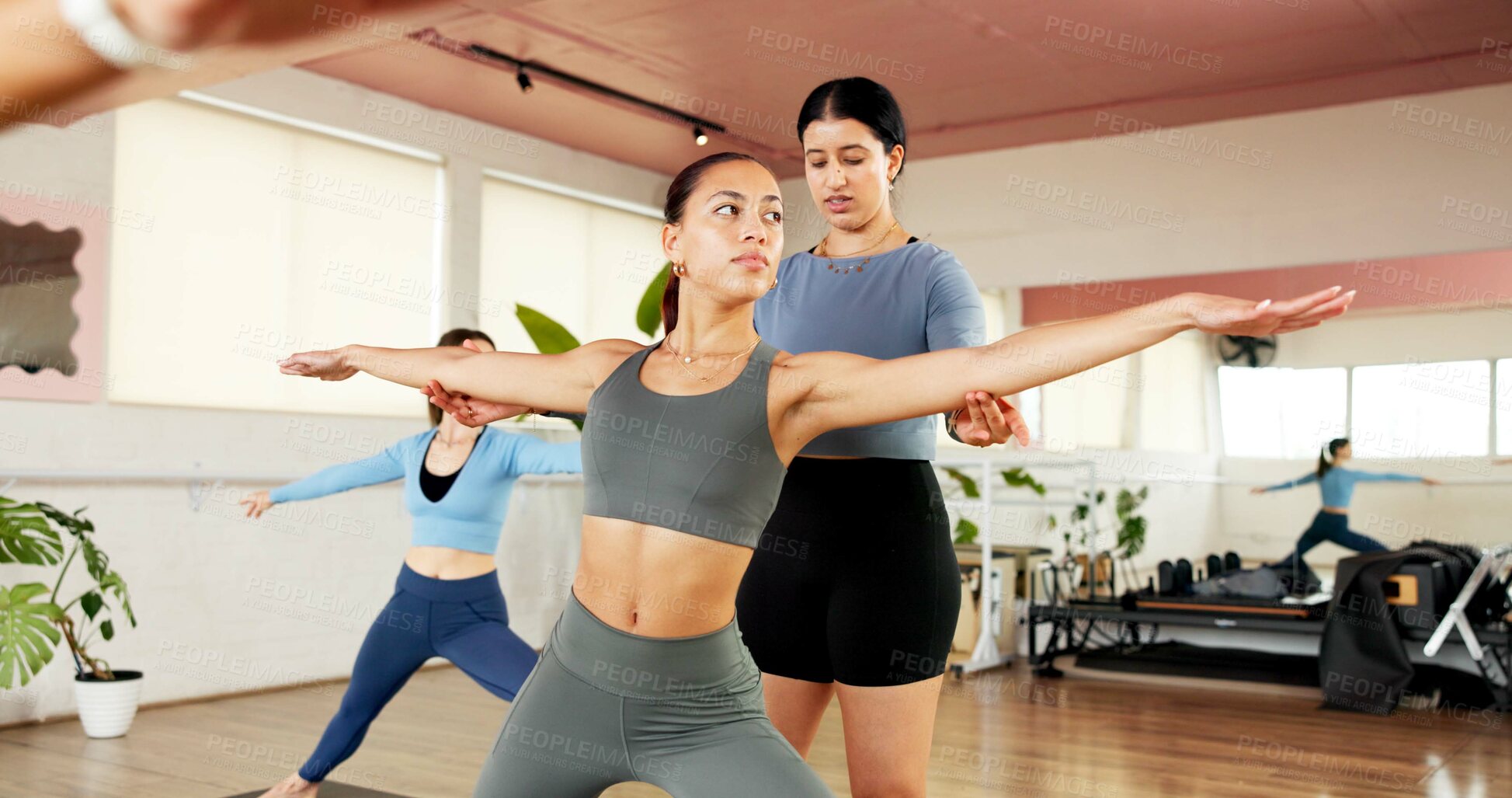 Buy stock photo Yoga class, women and help with instructor for fitness, body health and stretching for wellness. Yogi, exercise and coaching with people for warrior pose, balance and support with guidance in studio