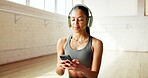 Music, phone and yoga with woman in studio for fitness tracking, holistic health or streaming. App, headphones and typing with yogi person in class for communication, subscription or wellness