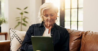 Buy stock photo Senior woman, tablet and reading in living room with online news, blog post and sofa. Relax, digital tech and mature person with app, internet scroll or social media in home for retirement with flare