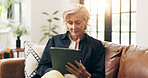 Senior woman, tablet and relax on sofa with scroll, notification or reading ebook in lounge at home. Elderly person, tech and smile with application, story and video on social media in retirement
