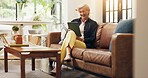 Senior woman, tablet and laugh on sofa with joke, notification or reading ebook in lounge at house. Elderly person, tech and relax on app, flare and funny video with social media in retirement home