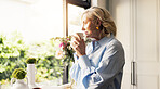Coffee, thinking and senior woman by window in home for reflection, memory or dreaming in morning. Cappuccino, ideas and elderly female person drinking warm beverage for retirement in apartment.