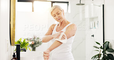 Buy stock photo Skincare, woman and dry brush in bathroom for skin exfoliation, lymphatic drainage and self care. Beauty, mature person and body scrub in home for anti aging benefits, cellulite reduction or radiance