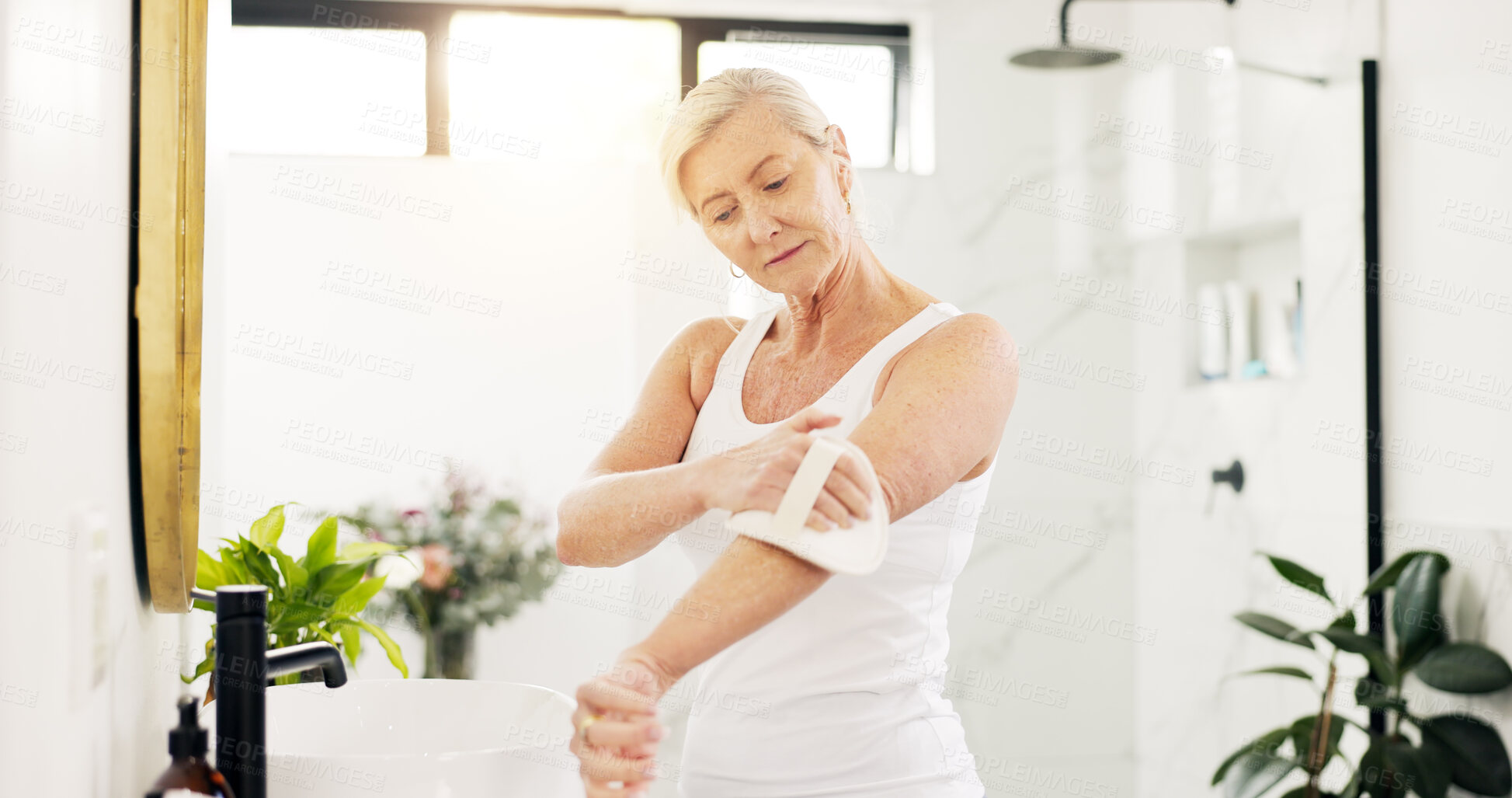 Buy stock photo Skincare, woman and dry brush in bathroom for skin exfoliation, lymphatic drainage and self care. Beauty, mature person and body scrub in home for anti aging benefits, cellulite reduction or radiance