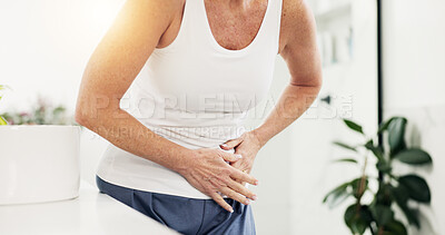 Buy stock photo Hands, mature woman and stomach pain in bathroom with indigestion, constipation and IBS symptoms. Home, sick person and tummy bloating in morning with belly discomfort, endometriosis or ovarian cysts