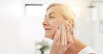 Mature woman, skincare and cream in bathroom for hydration, moisturizer and smile for beauty in home. Person, product and morning routine for anti aging, dermatology and flare with touch in house