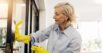 Buy stock photo Mature woman, cloth and cleaning window in home for hygiene, bacteria or dirt in morning. Person, chores and chemical with gloves, sanitation or bottle for germs, virus or dust on front door in house