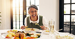 Mature, happy woman and laughing with food for funny joke, humor or comedy at dinner table in home. Female person, eating and feast with laughter, smile or plate for feast, social or gathering