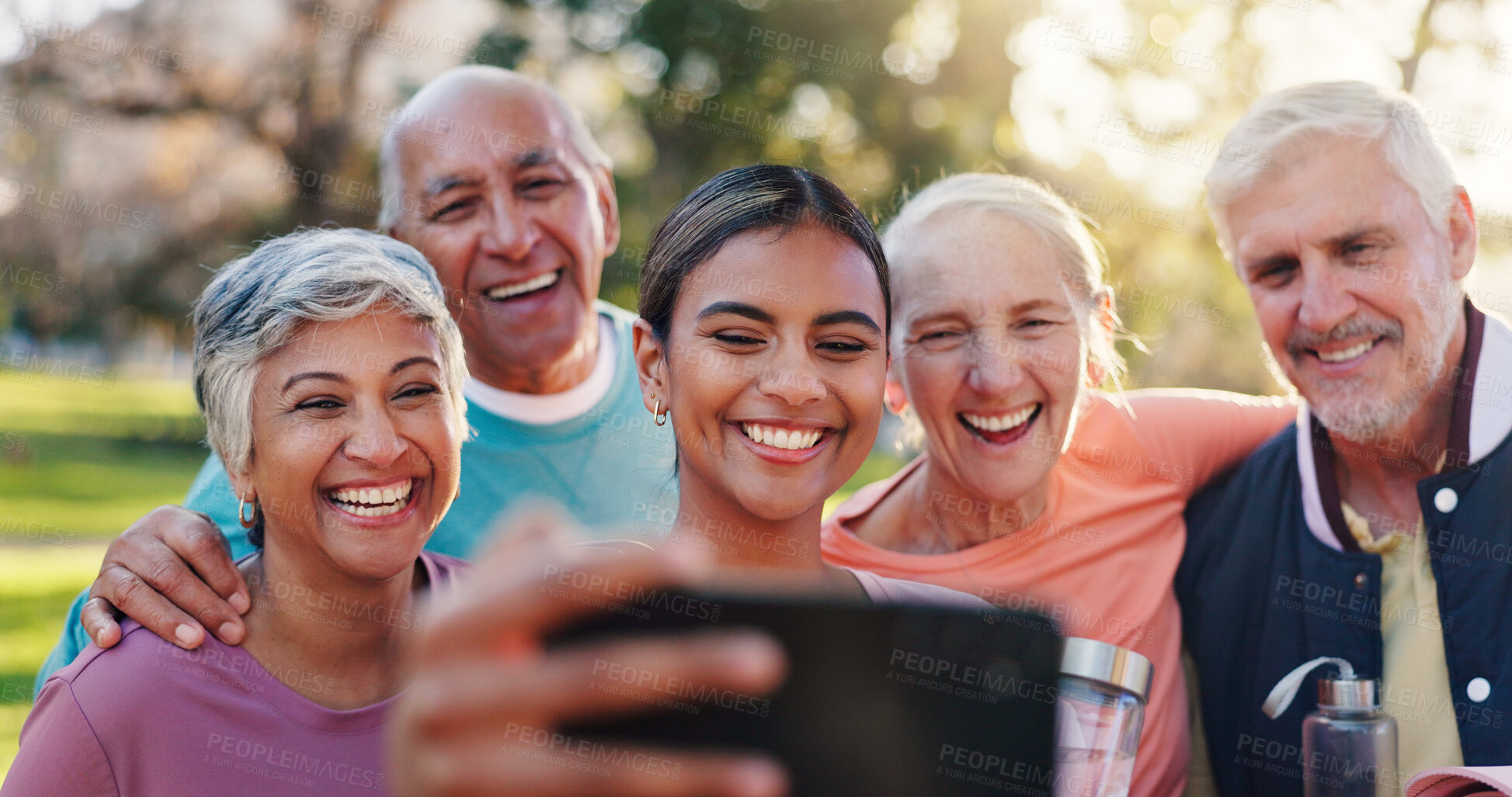 Buy stock photo Senior people, friends and selfie with personal trainer, hug and smile in park for summer and bonding. Mature group, men and women with embrace for fitness, profile picture and workout memory