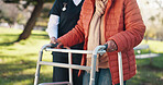 Outdoor, caregiver and old person with walker, hands and support for rehabilitation, help and trust. Physical therapy, nurse or assistance for senior patient with arthritis, health and care in nature