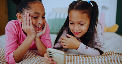 Buy stock photo Relax, laugh and kids on phone in bedroom for online entertainment, watching cartoons and movie. Family home, siblings and happy girls on tech for streaming videos, bonding and playing games on bed