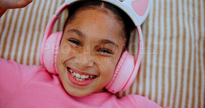 Buy stock photo Above, headphones and happy kid on bed for audio, streaming service and relax with portrait. Face, top view and girl in bedroom for music, online radio and child listening to sound to chill in home