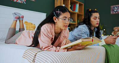 Buy stock photo Friends, phone and girls reading book in bedroom for studying, learning or research. Textbook, mobile and women relax on bed for education, test preparation and knowledge with students in home