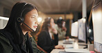 Woman, call center and reading with headset at night for customer service or consulting at office. Female person, employee or agent talking for communication, typing and overtime at workplace