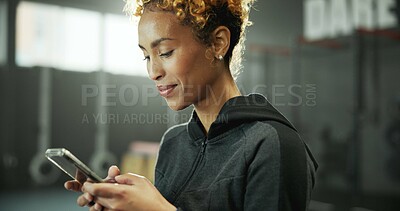 Buy stock photo Woman, gym and reading with phone for social media, message or online post and break. Happy african person, sports center and fitness with smile on internet for tutorial, chatting or notification