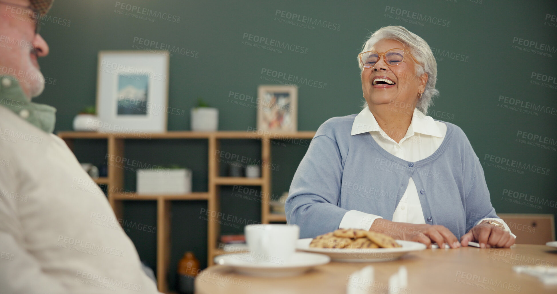 Buy stock photo Retirement, tea time and couple in house with cookies, laughing and bonding together during lunch. Happiness, old man and woman at table with biscuits, funny memory and relax in nursing home.