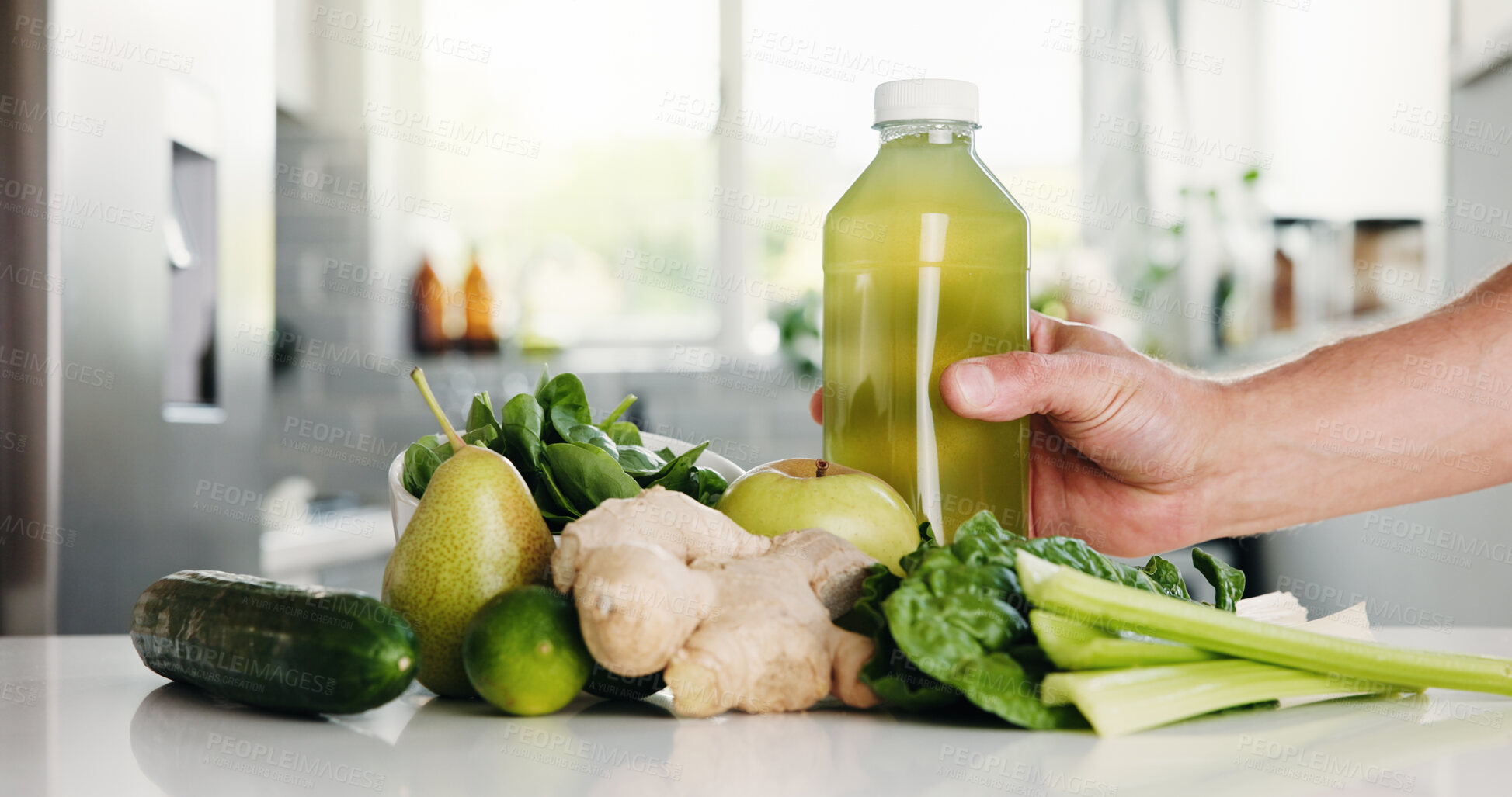 Buy stock photo Green, ingredients and hand with bottle in kitchen for detox, vitamin drink and wellness benefits. Nutrition, gut health and person in home with juice container, raw fruits and vegetable for diet