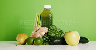 Buy stock photo Ingredients, smoothie and bottle in studio for detox, vitamin drink and wellness benefits. Nutrition, gut health and green background with juice container, raw fruits or vegetable for weight loss