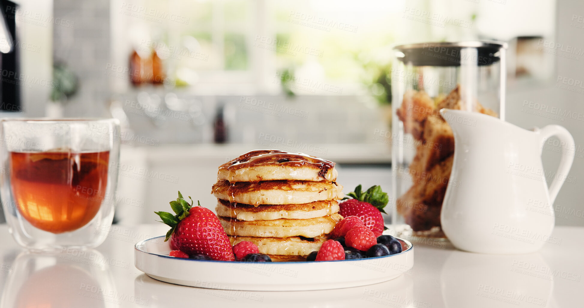Buy stock photo Tea, syrup and pancakes on counter in kitchen for meal prep, homemade breakfast and nutrition. Food, beverage and strawberry with sweet treat, brunch dessert and hotcakes snack for culinary at house