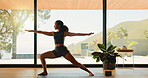 Woman, yoga and stretching with zen for fitness, balance or health and wellness in serene studio. Calm, female person or yogi with warrior pose for mindfulness, awareness or physical exercise in dojo