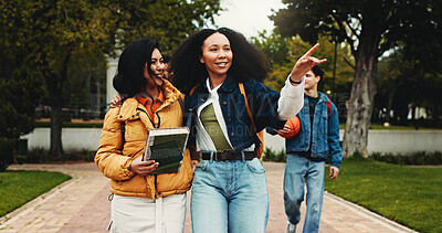 Buy stock photo Woman, students and walk at college, point and happy with story, direction and scholarship at academy. Girl, friends and discussion with smile, laugh and embrace outdoor at university for education