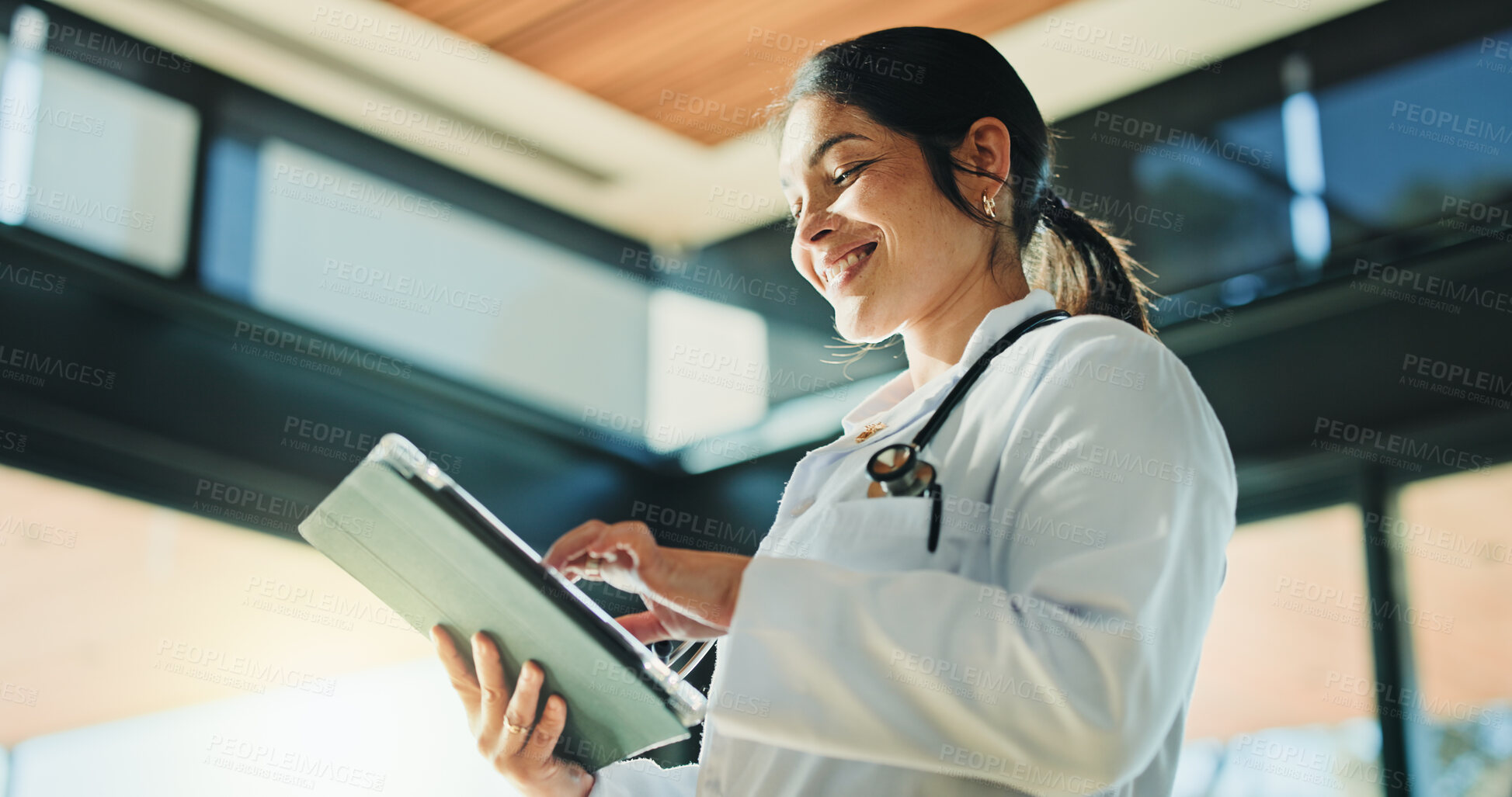 Buy stock photo Medical, low angle or woman in hospital with tablet, telehealth or positive results in patient treatment. Healthcare, smile or doctor in clinic with tech, online service or good news in diagnosis.