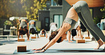 Yoga class, stretching and instructor with group, outdoor and routine to improve posture or fitness. Healthy, people and balance for downward facing dog at wellness center, self awareness or flexible