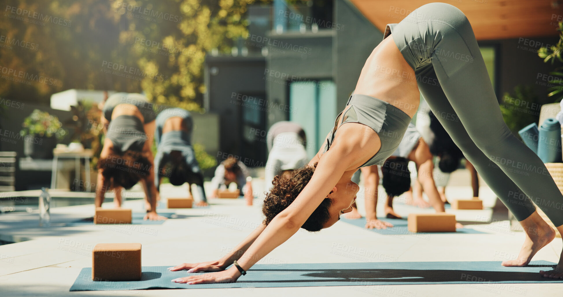 Buy stock photo Yoga class, stretching and instructor with group, outdoor and routine to improve posture or fitness. Healthy, people or balance for downward facing dog at wellness retreat, self awareness or flexible