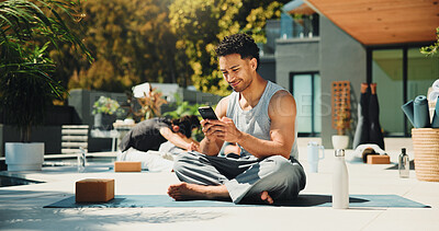 Buy stock photo Yoga, reading and phone with man in class for spiritual retreat, social media and communication. Pilates workout app, wellness club and online mindfulness guide with person outdoor for fitness
