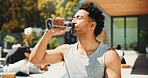 Drinking, outdoor and man with water at fitness class for break, relax or recovery on wellness retreat. Calm, rest and male person with healthy beverage for hydration at workout session on holiday.