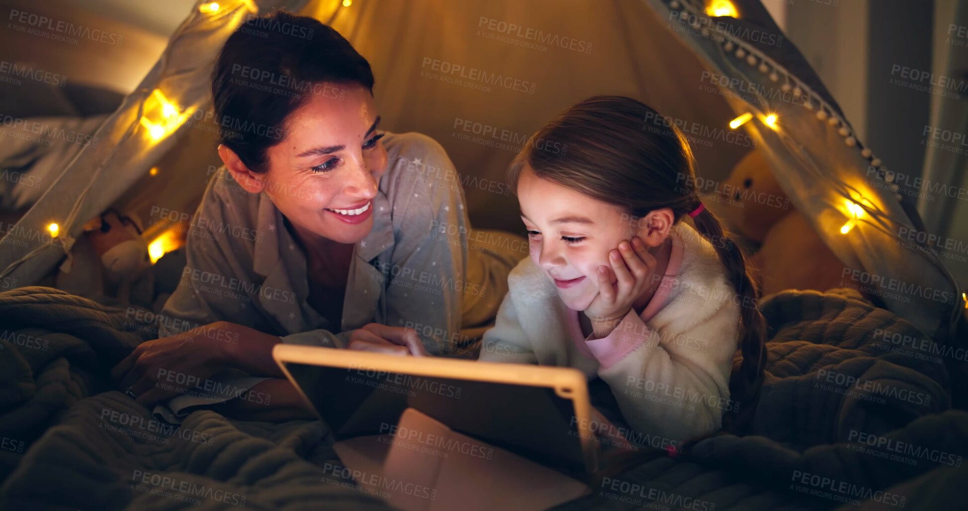 Buy stock photo Night, mother or child with tablet in tent for bonding together, reading ebook or bedtime story. Happy, parent or daughter with tech in home for online fairytale, kids storytelling app or literature.